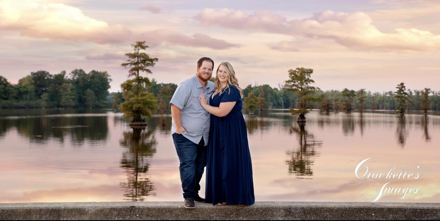 Engagement photo with couple at sunset by a lake