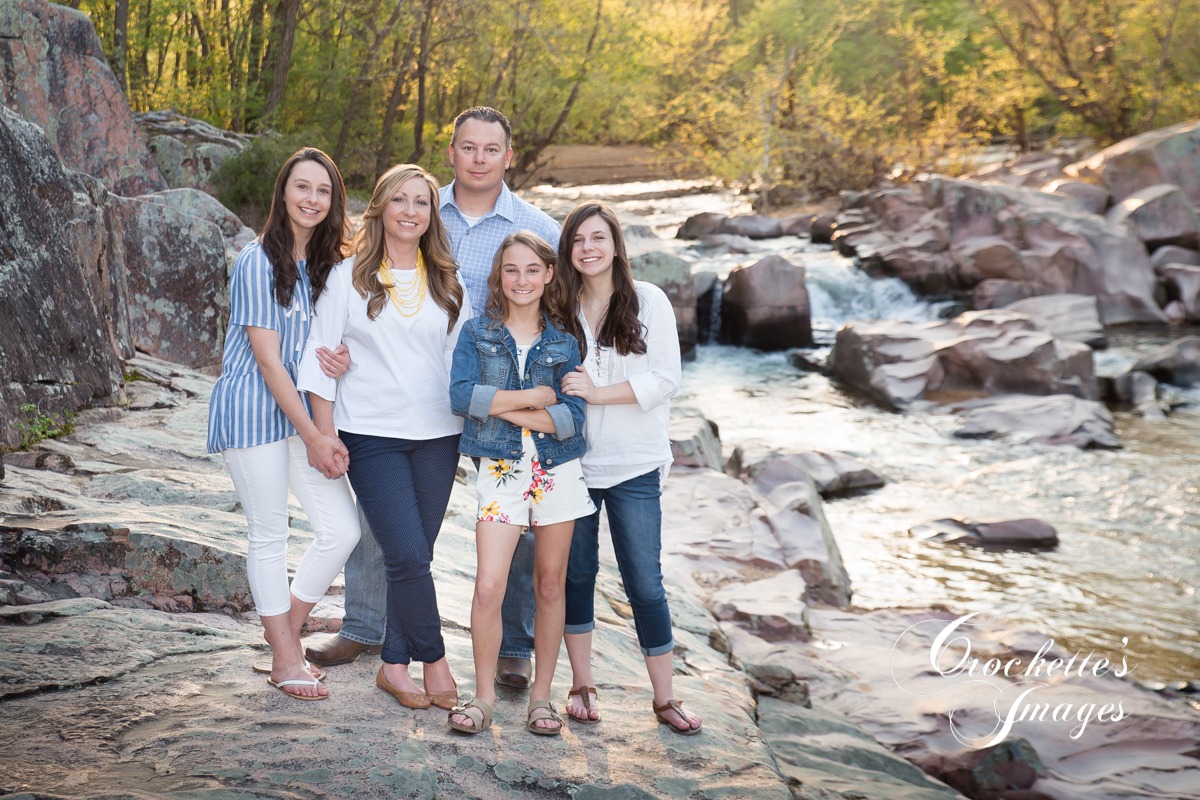 Classy Family photo in a creek wearing blue and white