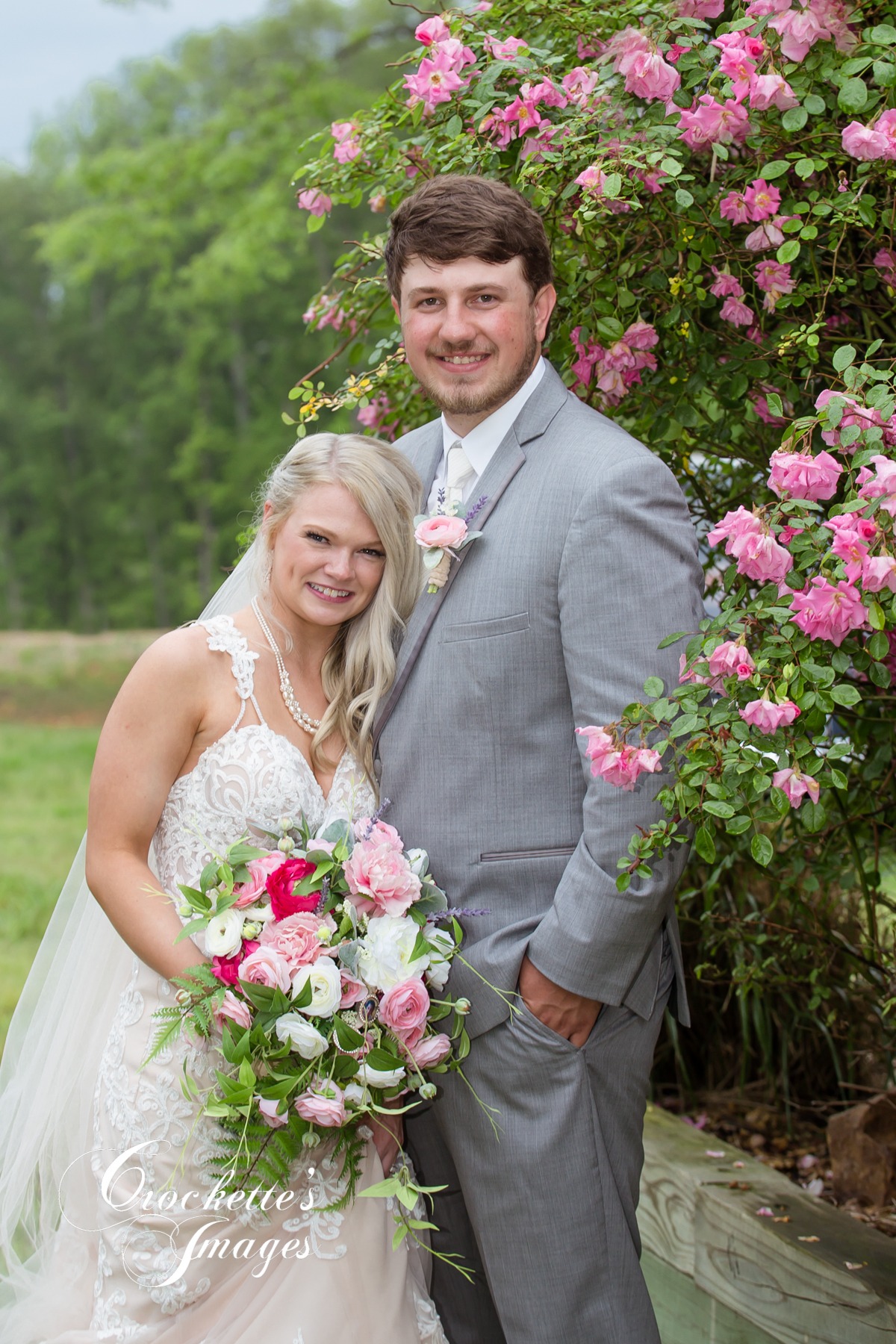 Lovely wedding couple surrounded by pink flowers