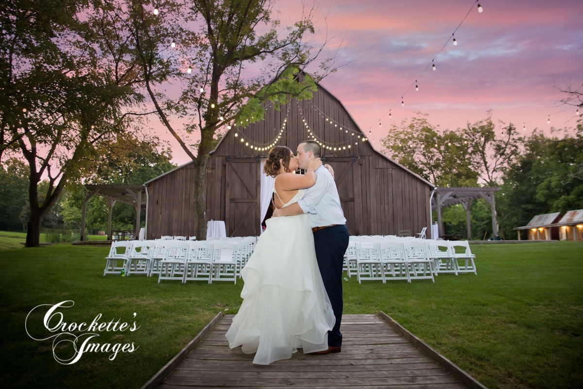 Wedding photo with couple kissing at sunset at Rusted Route Farms in Jackson, MO