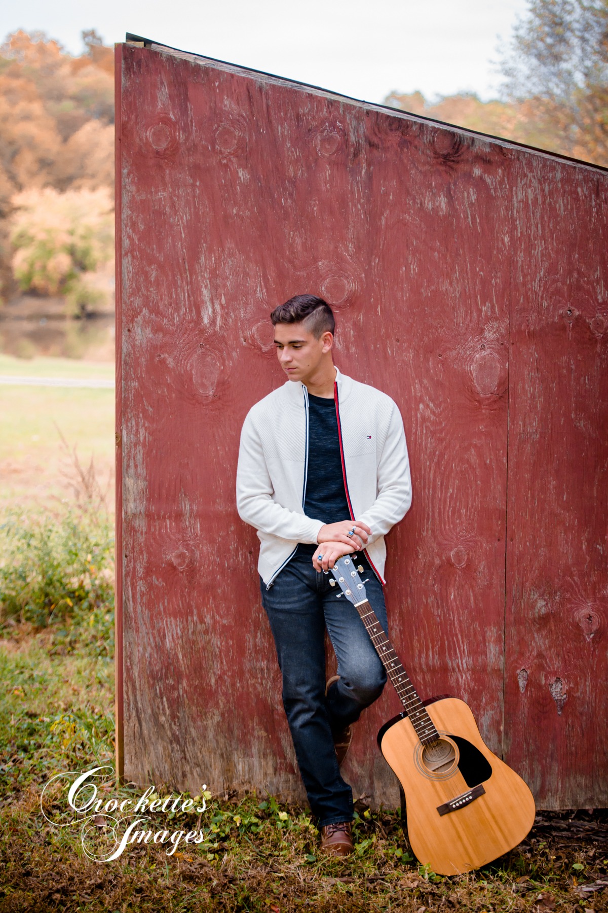 Fall Senior Boy photo with his guitar leaving against a red barn