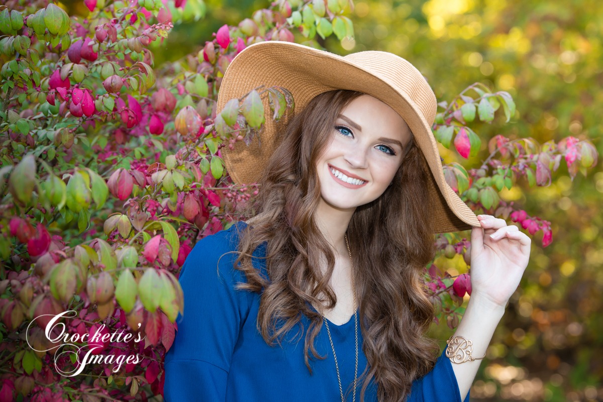 Classy and fun senior girl photo wearing a blue dress and big sun hat.