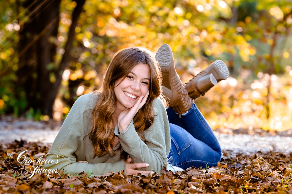 Summer senior photo with beautiful girl sitting on gravel road