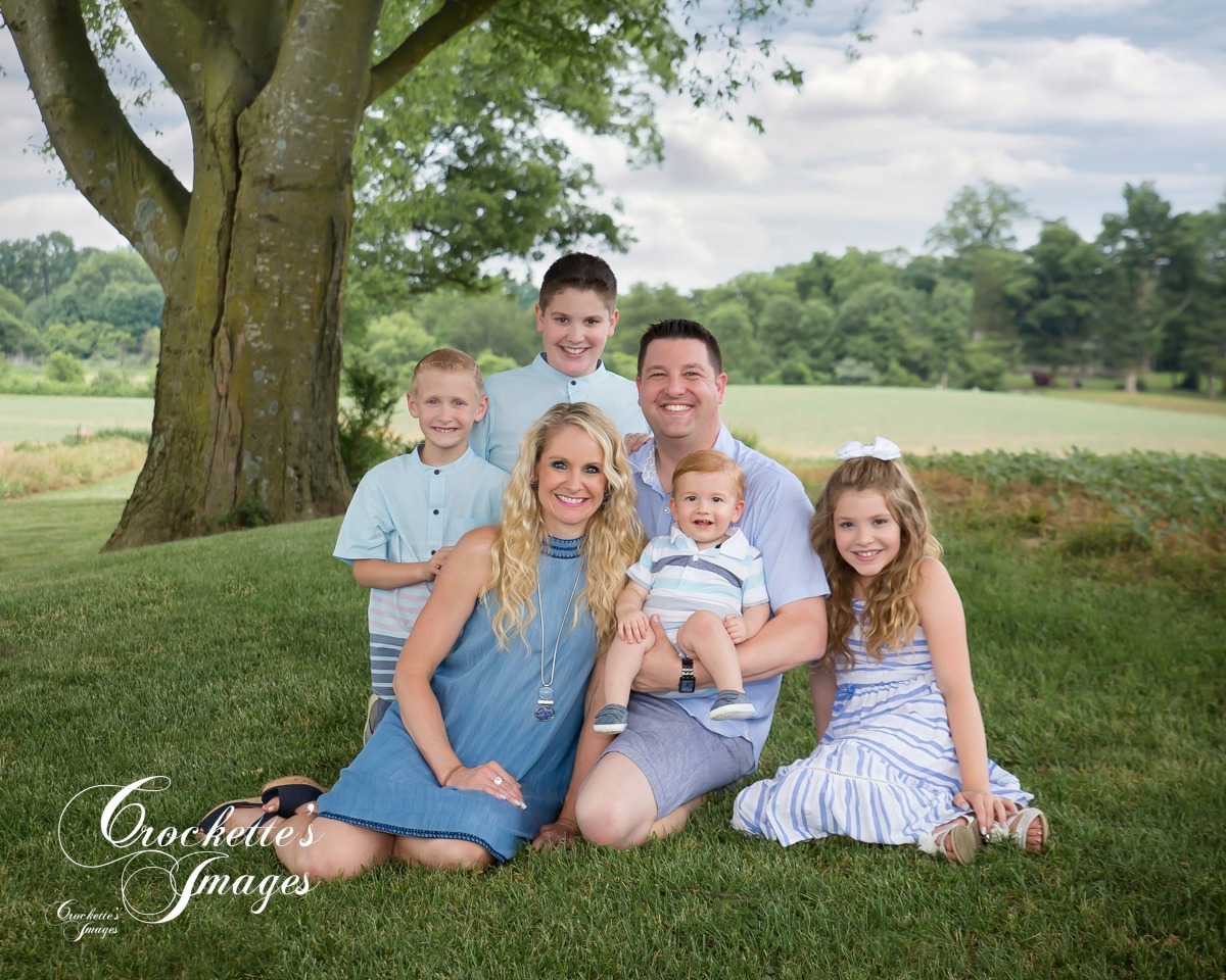 Classy Family photo in a creek wearing blue and white