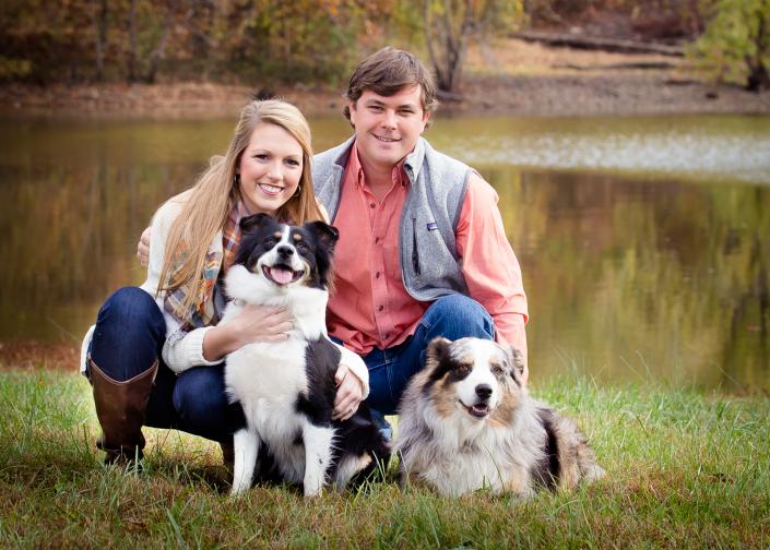 couple posting with two dogs