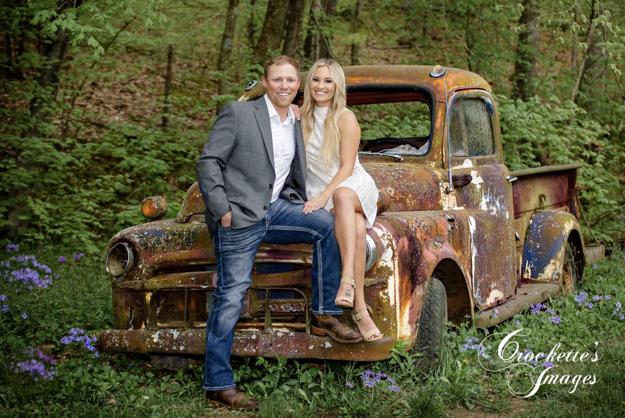 Spring, Classy, Elegant Country Engagement Photo with couple on a rusty truck sorrounded by flowers
