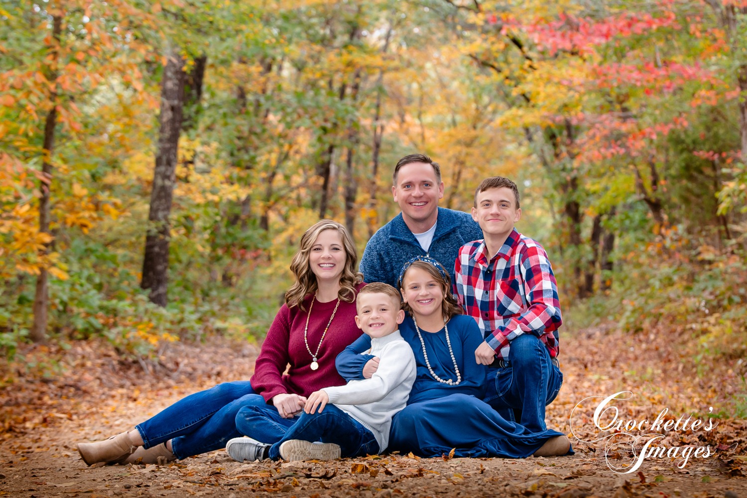 Classy Fall Family Photo on a gravel road in the woods. Navy, maroon, and white clothing color scheme.