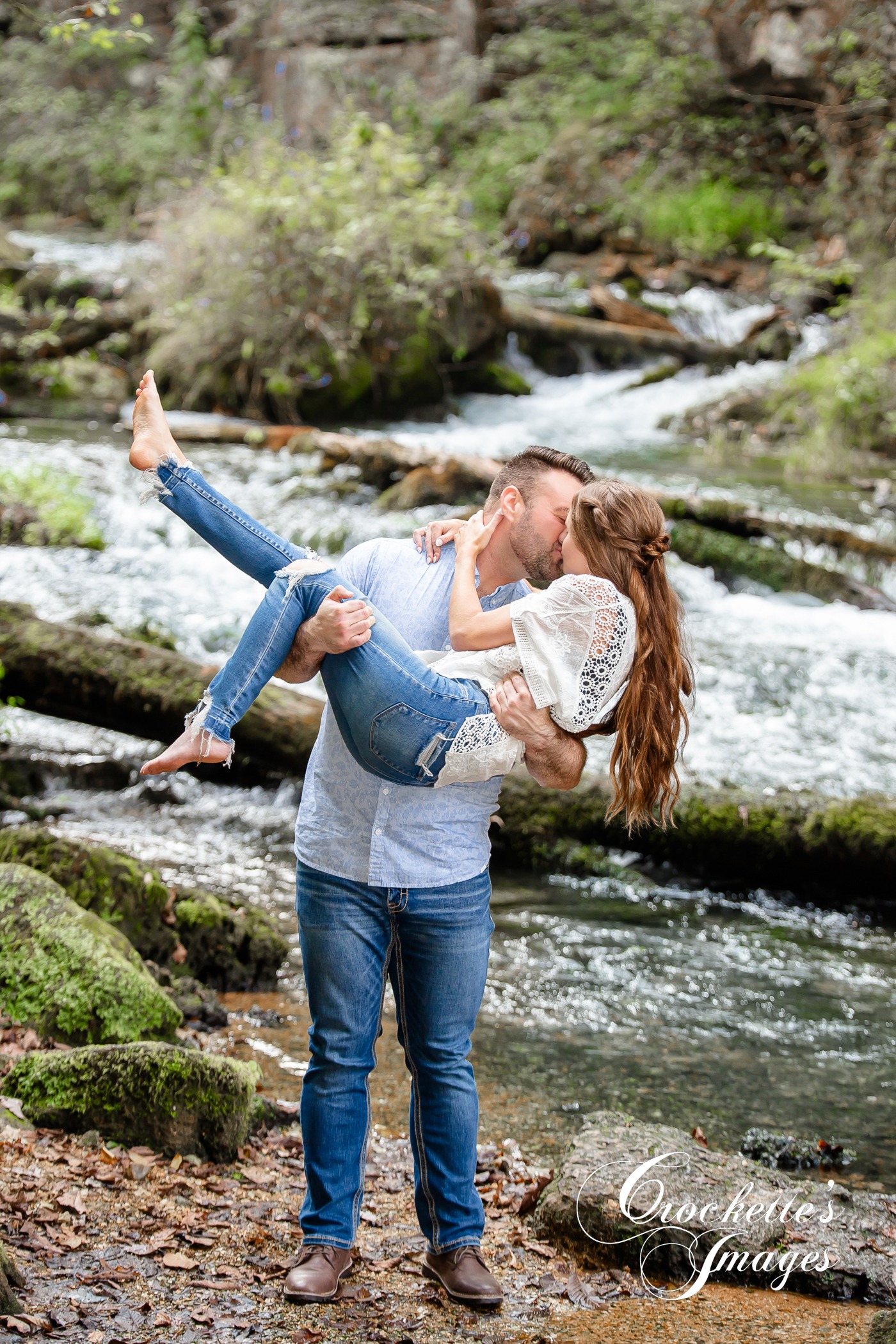 Dreamy engagement photo with couple kissing in a creek barefooted