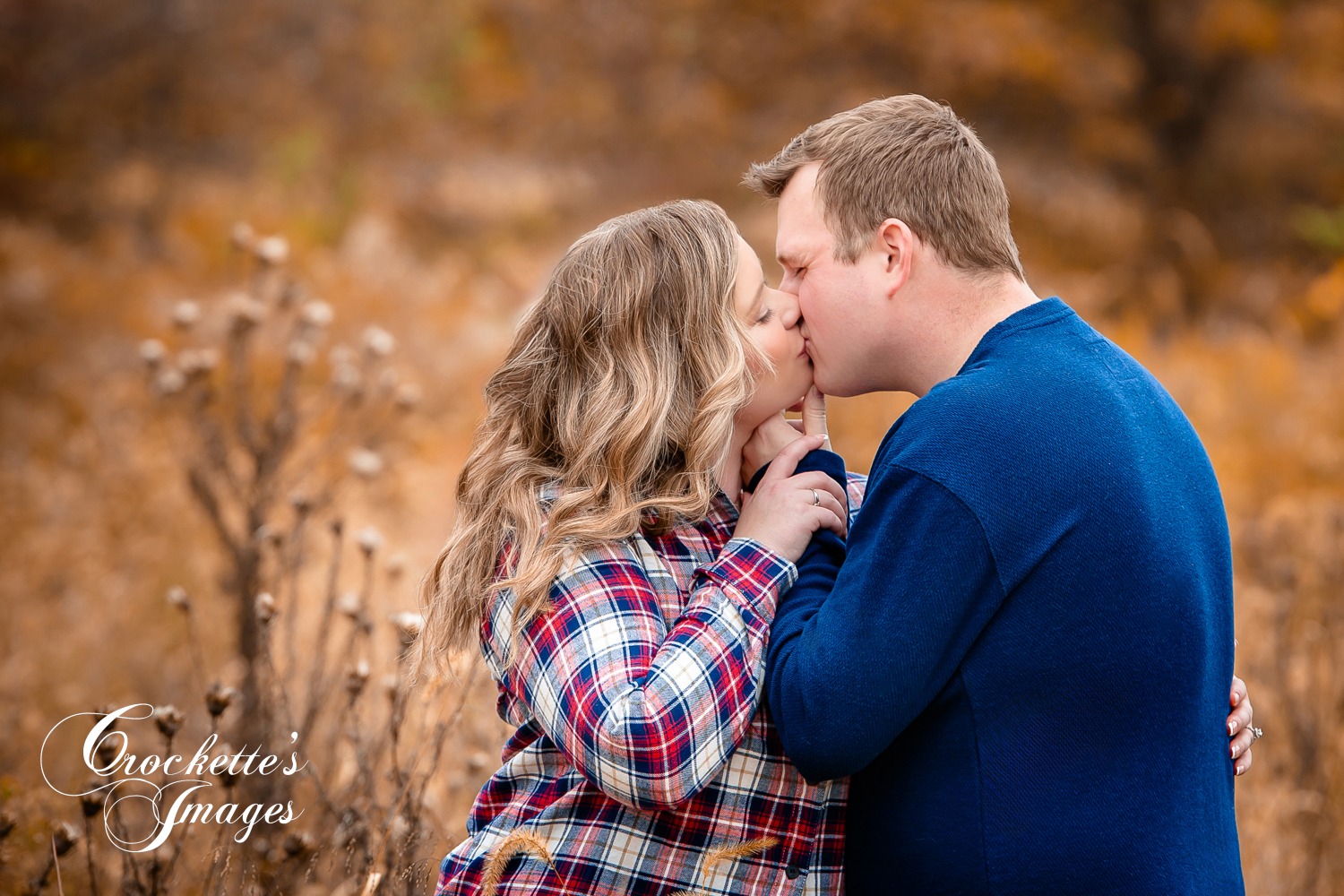 Romantic Fall Engagement Photo with couple kissing in a field