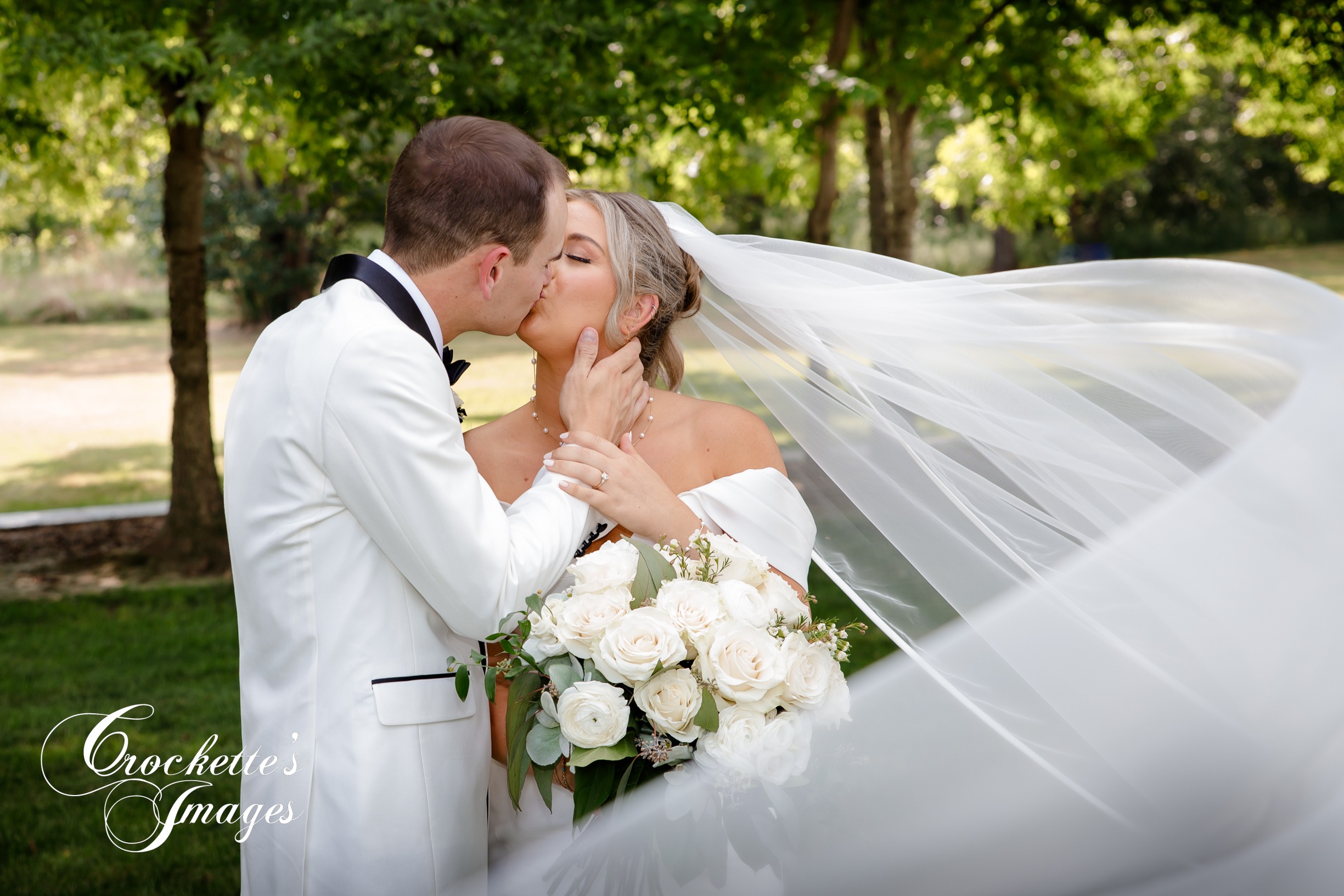 Bride & Groom kissing at Rusted Route with veil blowing in wind
