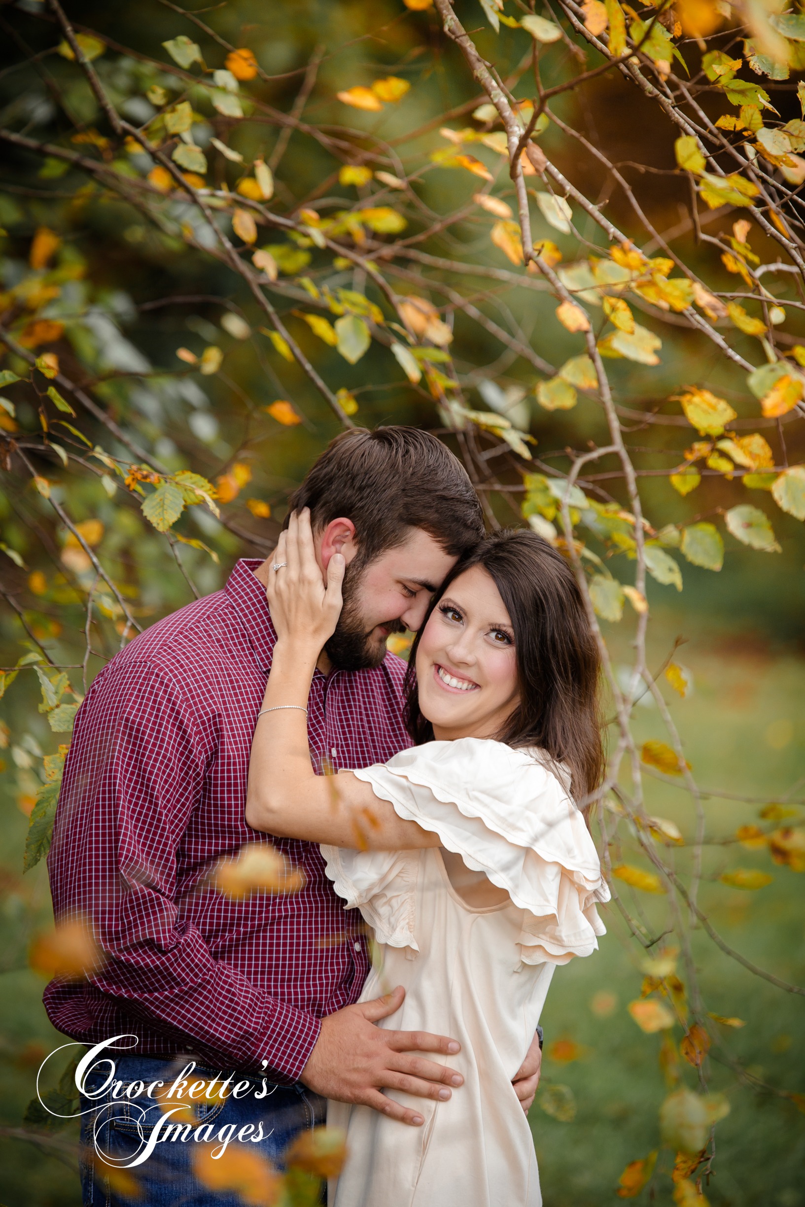 Fall engagement photo surrounded by wispy leaves
