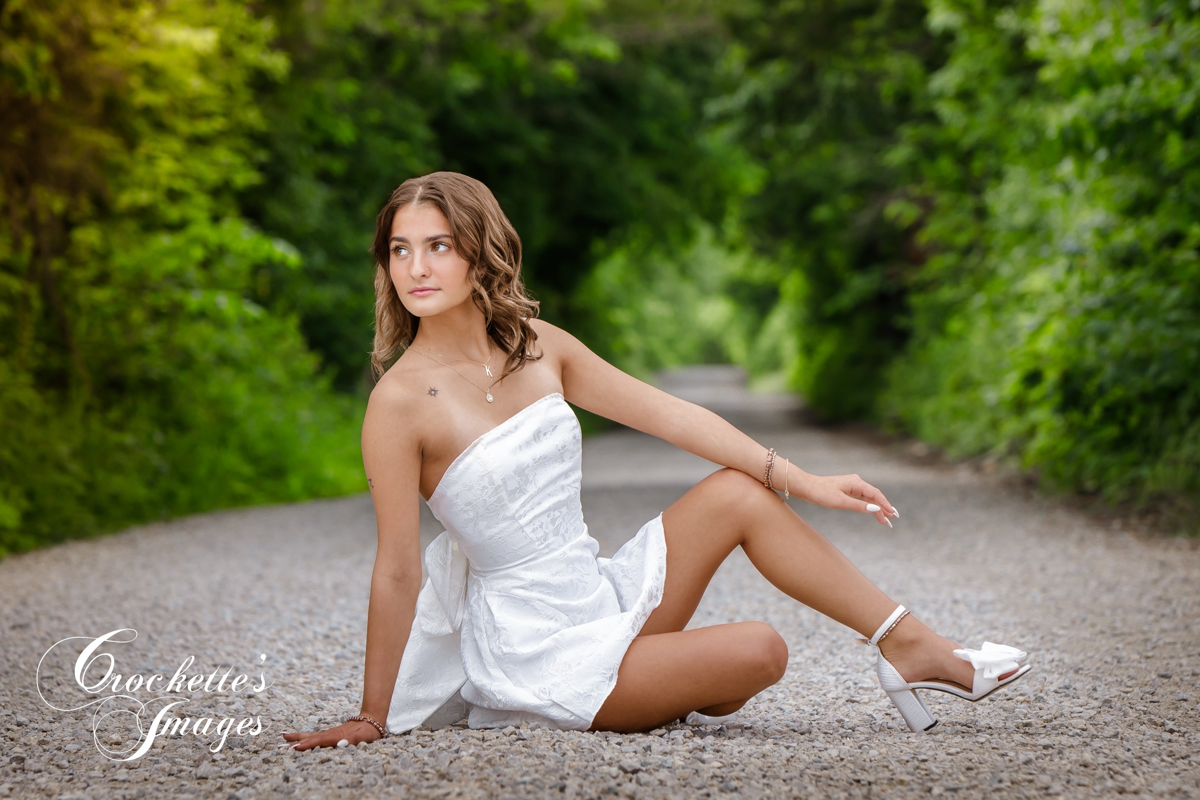 High School Senior Photo of a girl in a white dress on a gravel road