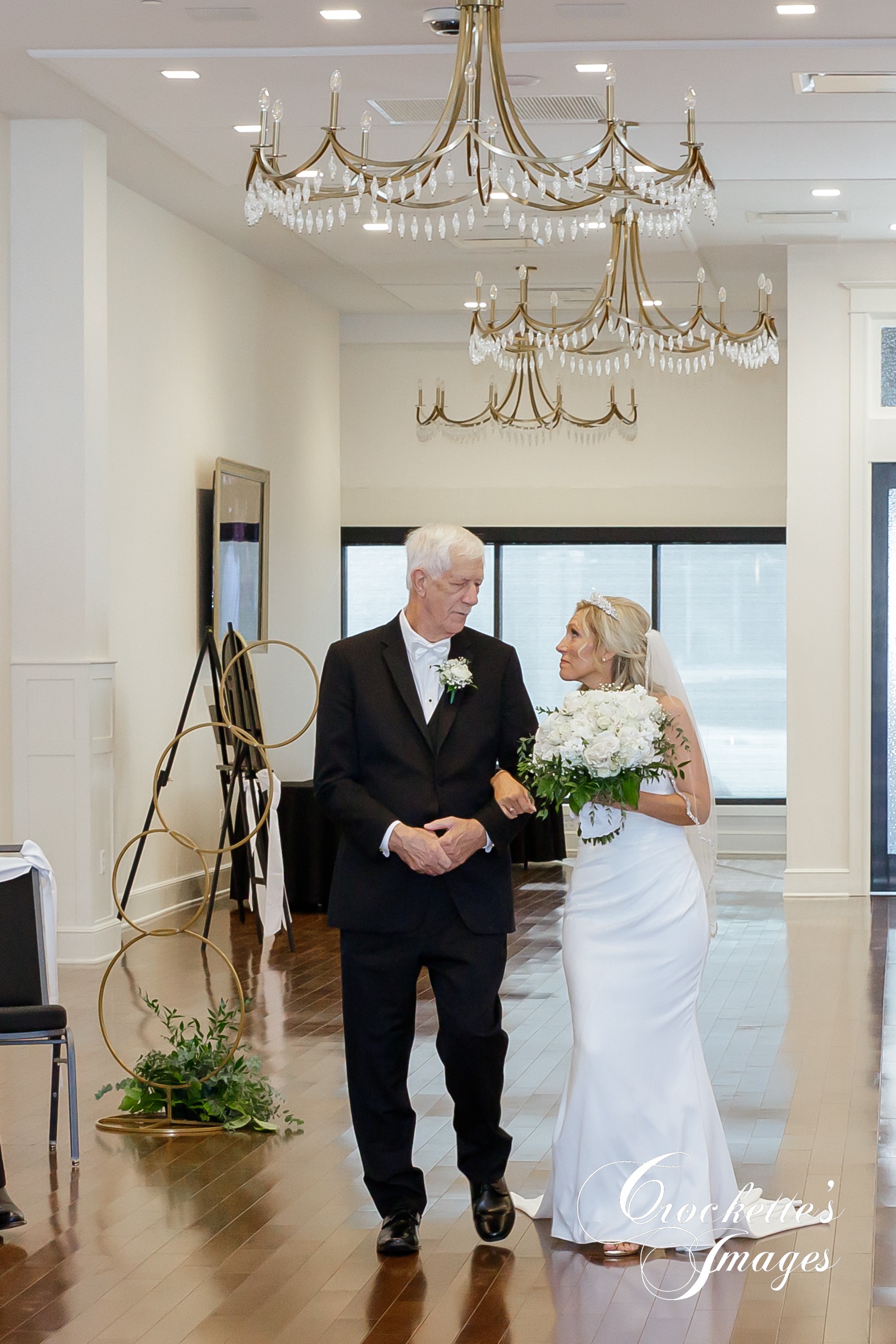 Father walking his daughter down the asile at a ceremony at The River View Room downtown Cape Girardeau, MO