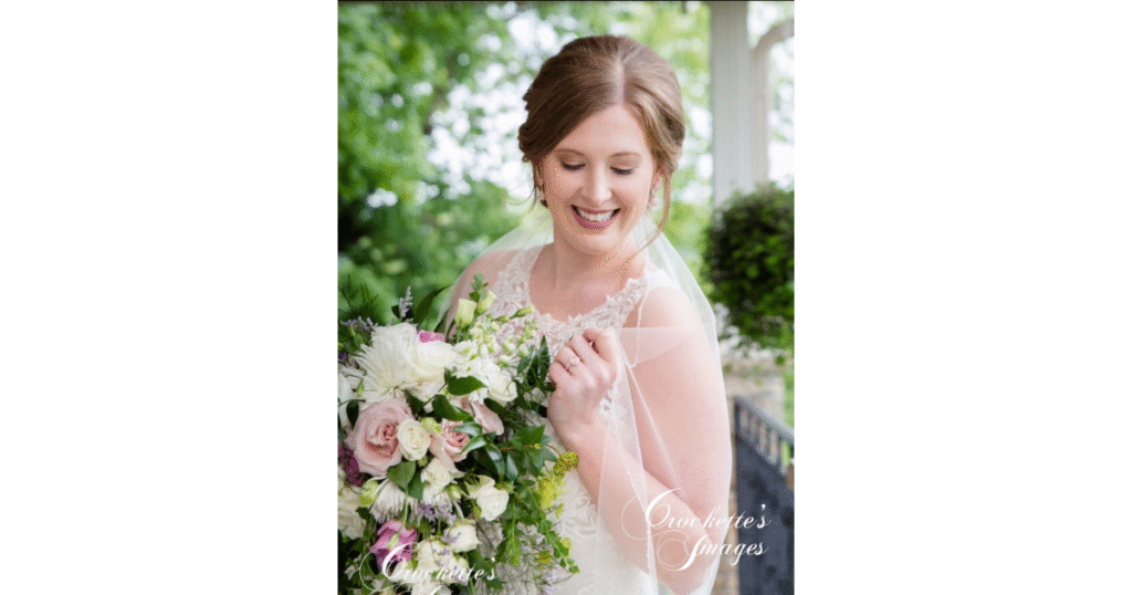 How to Pose With Your Bridal Bouquet for Timeless Wedding Photos You’ll Love Forever 14 Bridal portrait with bride looking bashfully down, holding her veil and posing her bridal bouquet.